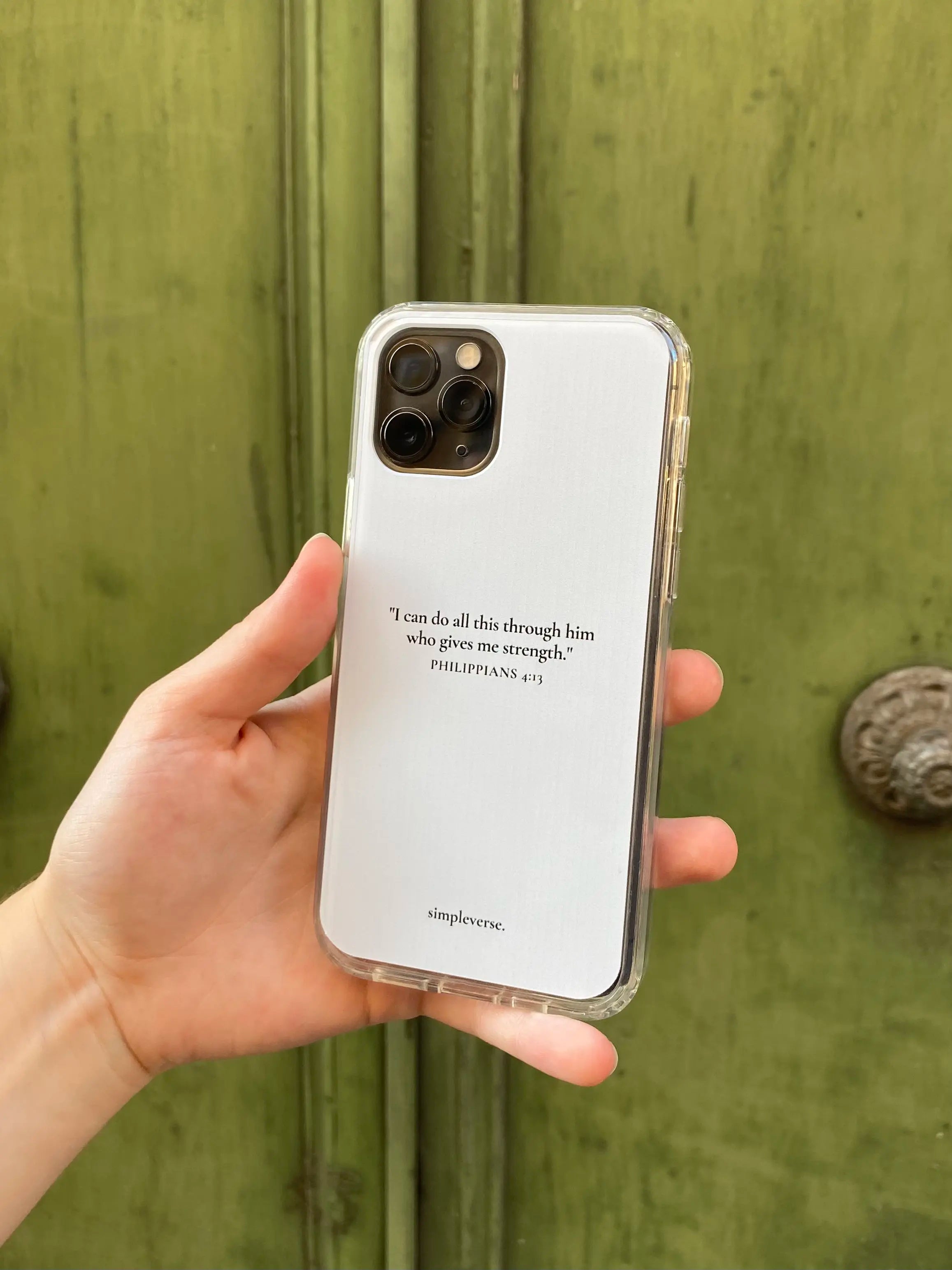 Hand holding a Christian iPhone case with 'Philippians 4:13' verse, reflecting personal faith and strength.