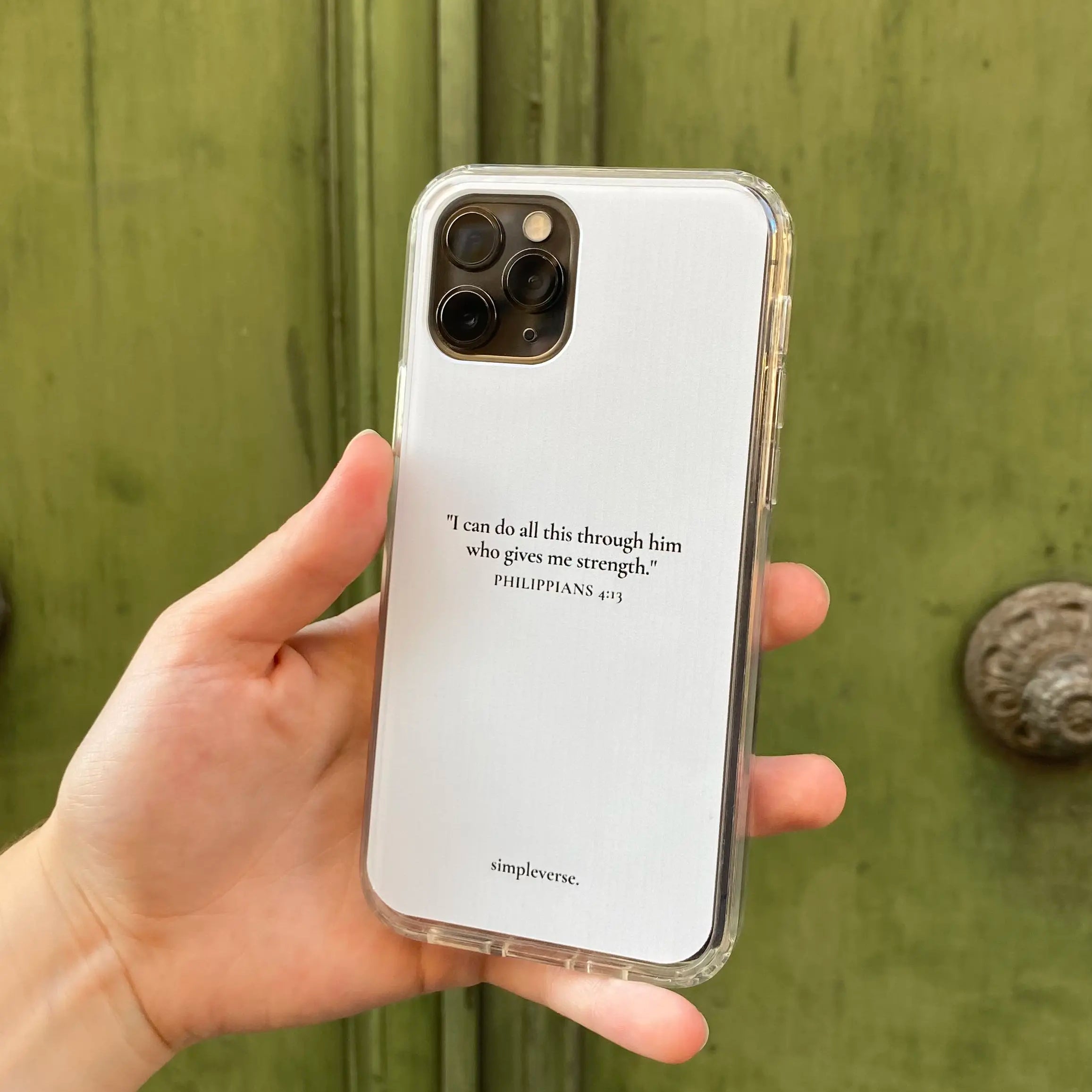 Hand holding a Christian iPhone case with 'Philippians 4:13' verse, reflecting personal faith and strength.