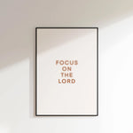 “Focus on the Lord” printable Christian wall art, minimalist text print on white wall.