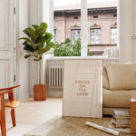 “Focus on the Lord” printable Christian poster on console in sunlit windowed living room.