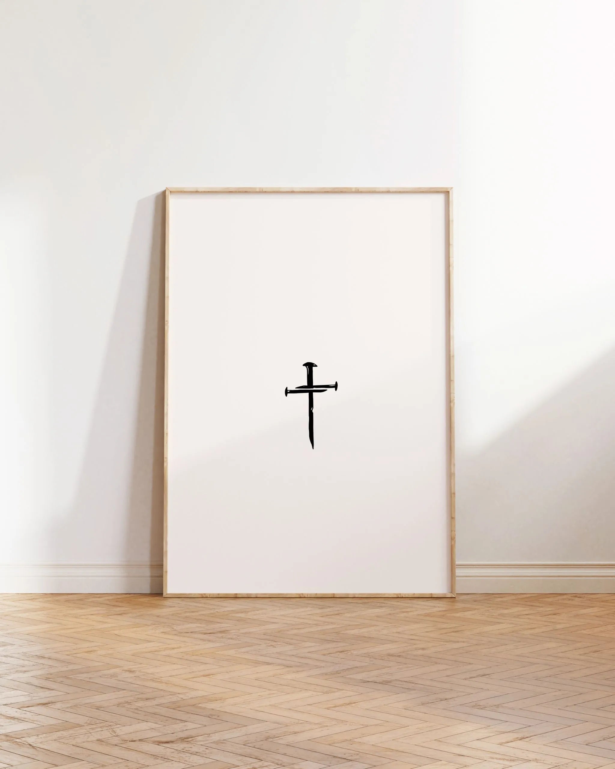 Nail Cross printable Christian poster leaning in lightwood frame on oak floor.