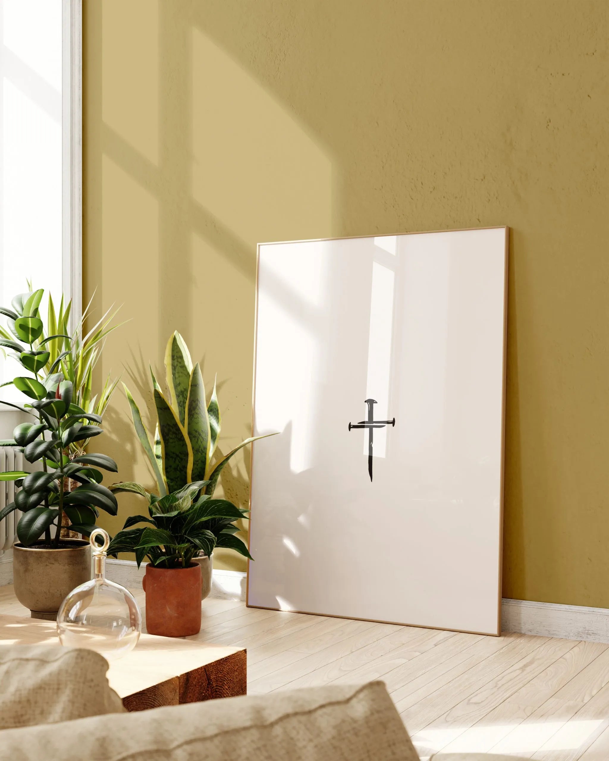 Nail Cross minimalist wall art in lightwood frame near plants, printable Christian décor.