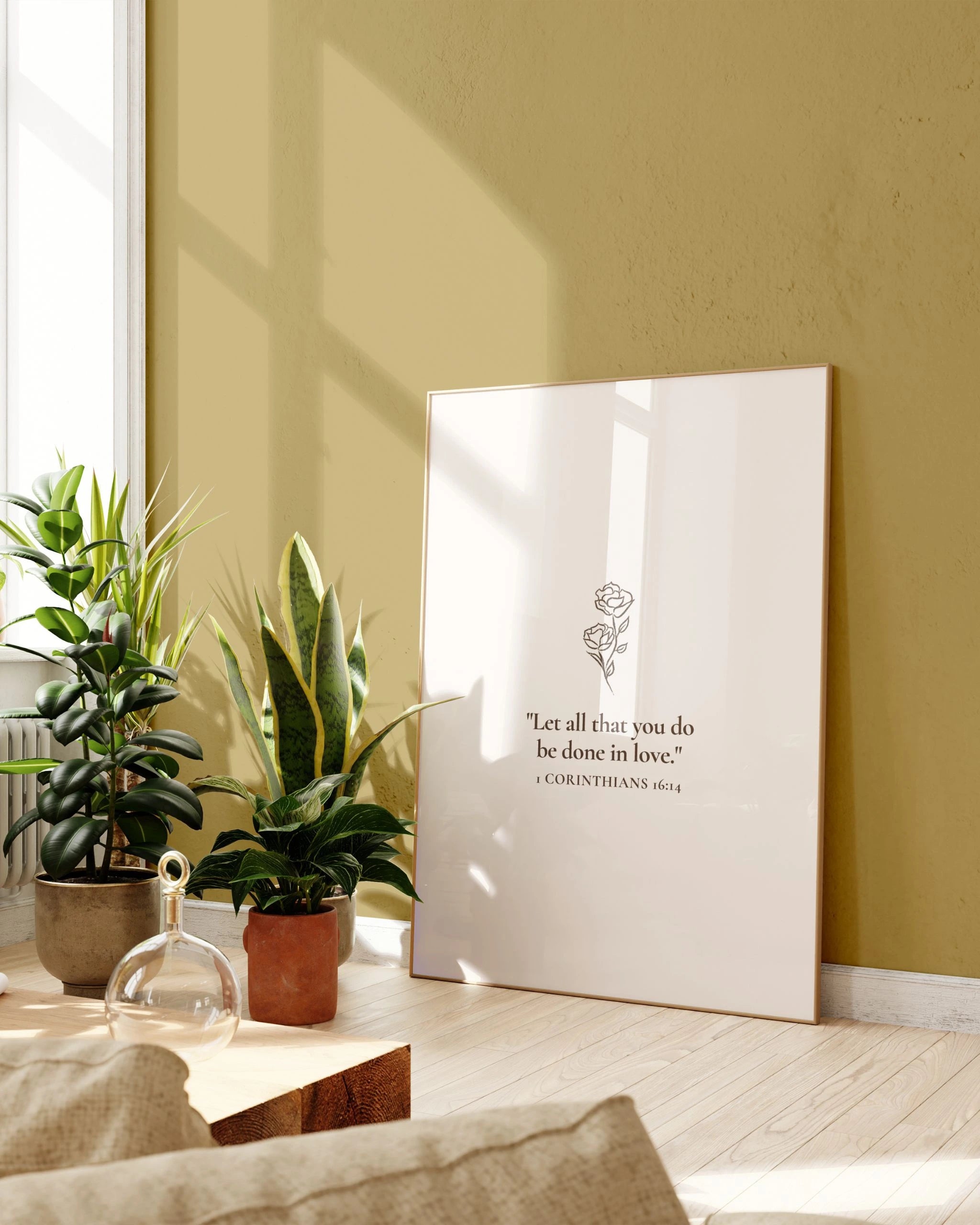 “All Things in Love” Christian wall art in bright room with plants.